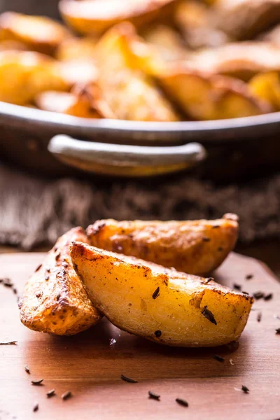 Patata. Patatas asadas. Patatas americanas con sal, pimienta y comino. Cuñas de patata asada deliciosa crujiente — Foto de Stock