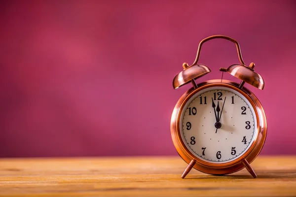 Retro alarm clock with two minutes to midnight. Filtered photo in vibrant colors 50s to 60s. Pink background — Stock Photo, Image