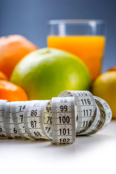 Meça fita adesiva e frutas frescas no fundo. Dieta de estilo de vida saudável com frutas tropicais frescas — Fotografia de Stock