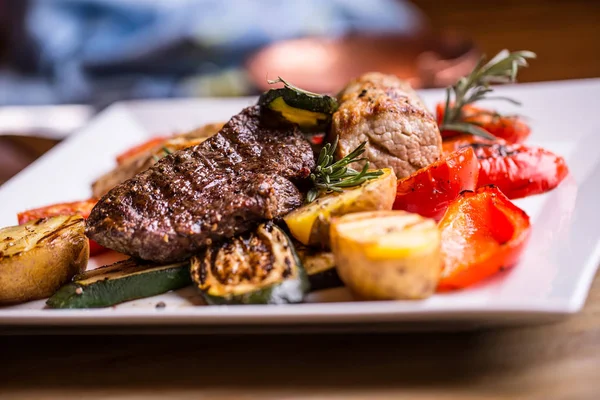 Nötstek. Ryggbiff. Läckra saftiga nötstek på gaffeln. grilla grönsaker — Stockfoto