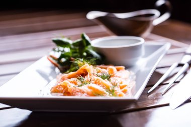 Somon balığı. Soyunma ve bitki dekorasyon ile somon füme dilimlenmiş. Hizmet veren bir restoran ya da otel de somon dilimlenmiş