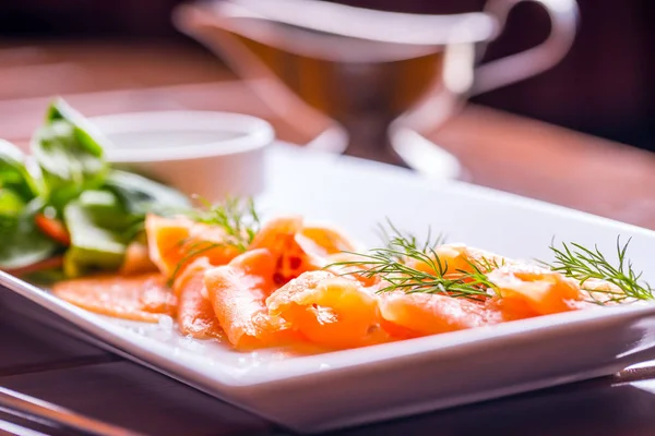 Du saumon. Saumon fumé tranché avec vinaigrette et décoration aux herbes. Servir du saumon tranché dans un restaurant ou un hôtel — Photo