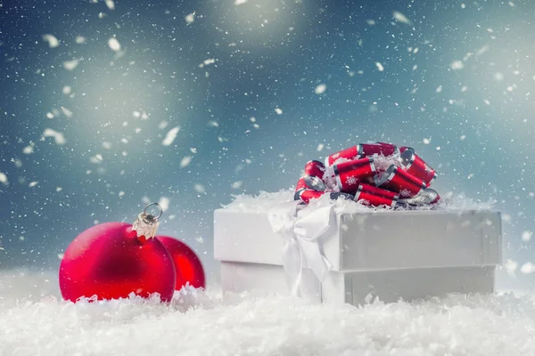 Caja de regalo de Navidad con bolas de Navidad en escena nevada abstracta —  Fotos de Stock