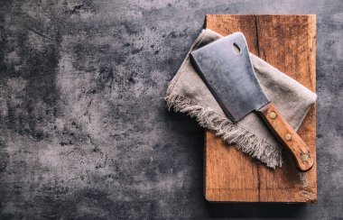 Kasap. Vintage kasap et cleavers karanlık beton veya ahşap mutfak gemide bez havlu ile