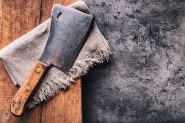 Kasap. Vintage kasap et cleavers karanlık beton veya ahşap mutfak gemide bez havlu ile