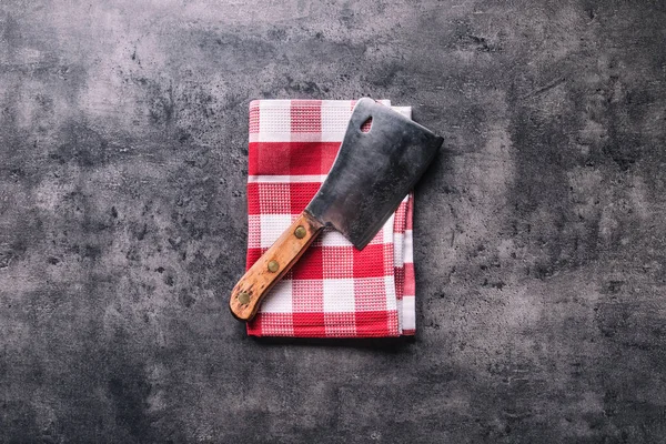 Carnicero. Cortadoras de carne de carnicero vintage con toalla de tela en hormigón oscuro o tablero de cocina de madera — Foto de Stock