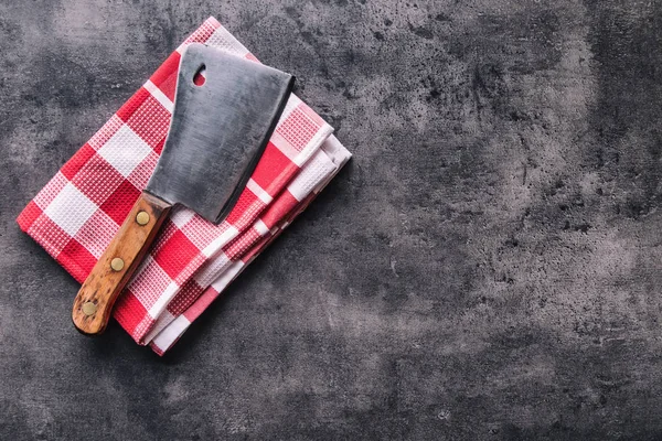 Carnicero. Cortadoras de carne de carnicero vintage con toalla de tela en hormigón oscuro o tablero de cocina de madera — Foto de Stock