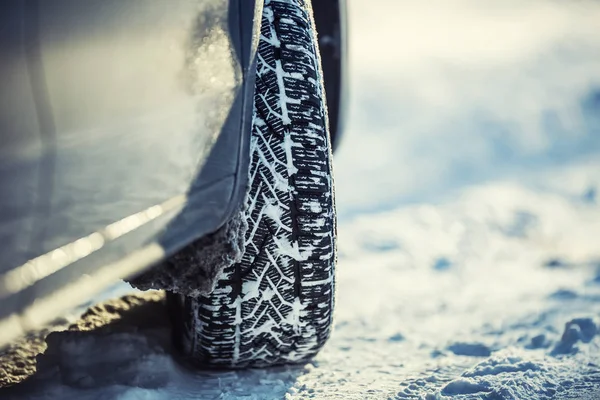 Primer plano de los neumáticos del coche en una carretera nevada.Blizzard en la carretera —  Fotos de Stock