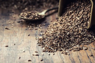 Cumin.Caraway tohumlar ahşap masa üzerinde. Vintage bronz kase ve kaşığı kimyon