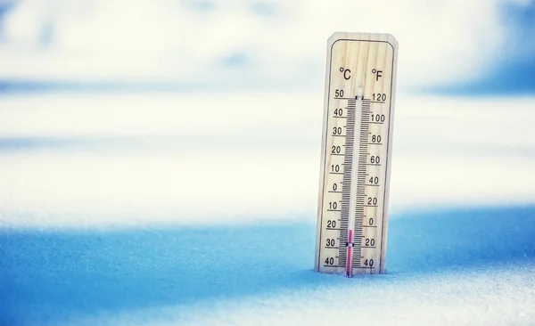 Termometer på snö visar låga temperaturer under noll. Låga temperaturer i grader Celsius och fahrenheit. Kall vinter väder tjugo under noll — Stockfoto