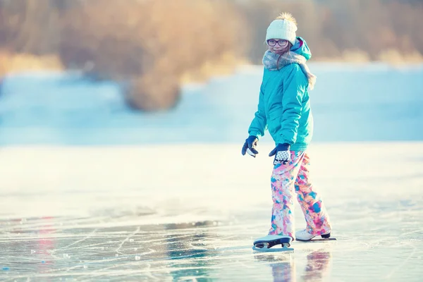 Ice skating. Young girl is skating on a natural frozen lake — Stock Photo, Image