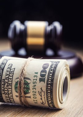 Hâkim'in çekiç tokmak. Adalet dolar banknot ve ABD bayrağı içinde belgili tanımlık geçmiş. Mahkeme tokmak ve haddelenmiş banknot. Natürmort bir rüşvet, yolsuzluk ABD'de yargı sistemi