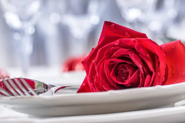 Apparecchiatura della tavola per San Valentino o il giorno del matrimonio con rose rosse. Romantico tavolo apparecchiato per due con piatti di rose tazze e posate — Foto Stock