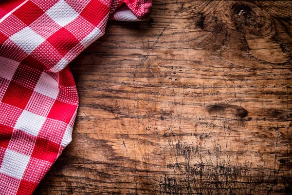 Top view of checkered tablecloth or napkin on empty wooden table — Stock Photo, Image