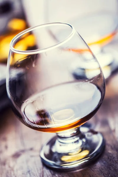 Cam viski konyak konyak veya ROM. Yarım tam bardak konyak ahşap yüzeye — Stok fotoğraf