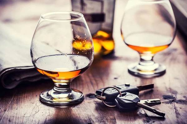 Alcoholismo. Copa de coñac o brandy mano hombre las llaves del coche y conductor irresponsable — Foto de Stock