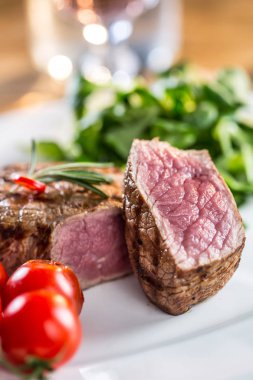 Sığır eti biftek. Sulu biftek biftek. Sebze ve ahşap masa üzerinde gül şarap gurme biftek