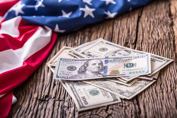 Dólares americanos una bandera de los E.E.U.U. Primer plano de la bandera americana y del dinero en efectivo del dólar en madera vieja del roble — Foto de Stock