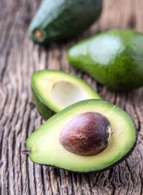 Avokado. Avokado bir meşe ahşap arka plan masaya kesilmiş. Seçici odak