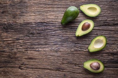 Avokado. Avokado bir meşe ahşap arka plan masaya kesilmiş. Seçici odak