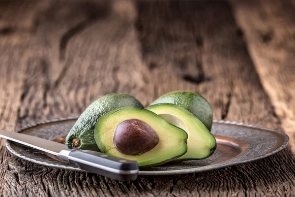 Avokado. Skär avokado på en ek trä bakgrundstabell. Selektivt fokus — Stockfoto