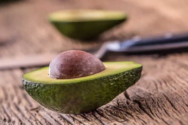 Avokado. Skär avokado på en ek trä bakgrundstabell. Selektivt fokus — Stockfoto