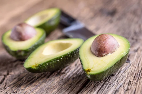 Avokado. Skär avokado på en ek trä bakgrundstabell. Selektivt fokus — Stockfoto