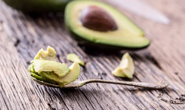 Avokado. Skär avokado på en ek trä bakgrundstabell. Selektivt fokus — Stockfoto