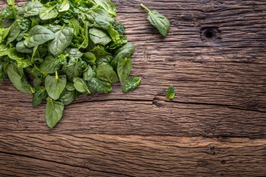 Ispanak yaprakları. Taze ıspanak retro kapta meşe ahşap tahta üzerinde yapraklar. Seçici odak