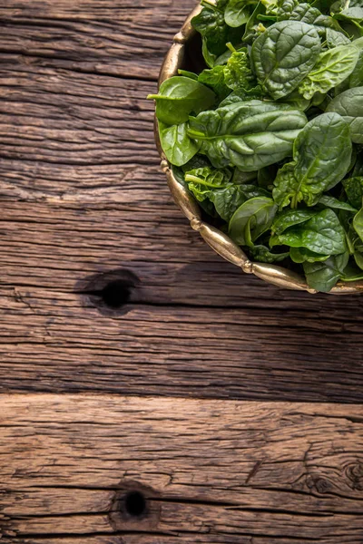 Spinach leaves.Fresh spinach leaves in retro bowl on oak wood board. Selective focus — Stock Photo, Image