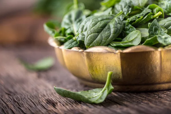 Spinach leaves.Fresh spinach leaves in retro bowl on oak wood board. Selective focus — Stock Photo, Image