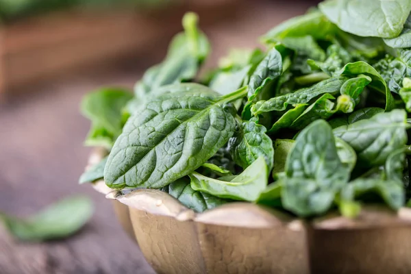 Spinach leaves.Fresh spinach leaves in retro bowl on oak wood board. Selective focus — Stock Photo, Image