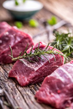 Bir kesme tahtası Biberiye Biber tuz diğer pozisyonlarda ile ham sığır bonfile biftek