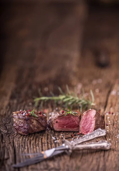 Grillezett marhahús steak rozmaringos, a sót és a borsot, a régi vágódeszka. — Stock Fotó