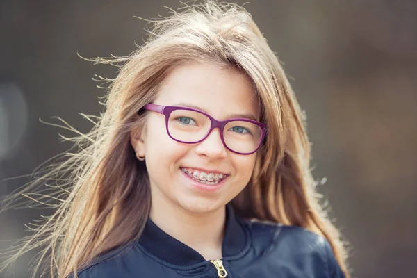 Girl. Teen. Pre teen. Girl with glasses. Girl with teeth braces. Young cute caucasian blond girl wearing teeth braces and glasses