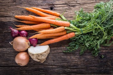 Havuç kereviz soğan. Eski meşe ahşap masa üzerinde taze sebze
