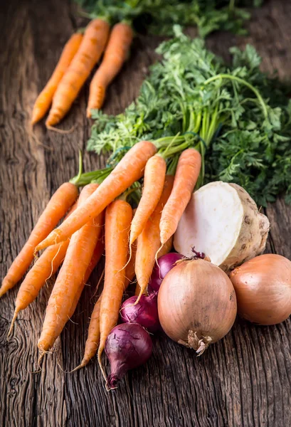 胡萝卜，芹菜和洋葱。老橡树木桌子上新鲜的蔬菜 — 图库照片