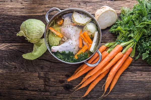 Top view of chicken soup -  broth on wooden table with vegetable — Stock Photo, Image