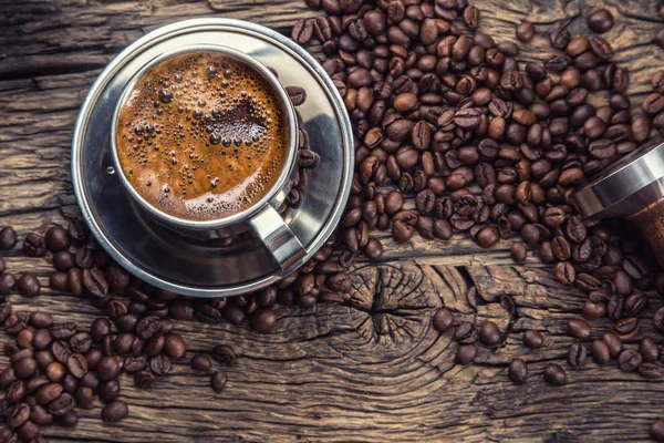 Kaffee. schwarzer Kaffee mit Kaffeebohnen und Portafilter auf altem Eichenholztisch — Stockfoto