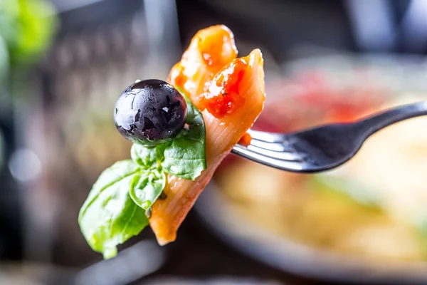 Pasta Penne med köttfärssås tomatsås, parmesanost Svart oliv och basilika på en gaffel. Mat från medelhavsköket. Italienska köket — Stockfoto
