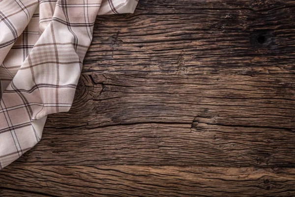 Top view of checkered tablecloth or napkin on empty wooden table — Stock Photo, Image