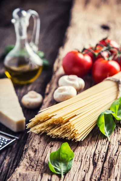 Spaghetti.Spaghetti domates fesleğen zeytinyağı parmesan peyniri ve mantarlar çok eski meşe tahtası üzerinde. Mediterrannean mutfağı ve malzemeler — Stok fotoğraf