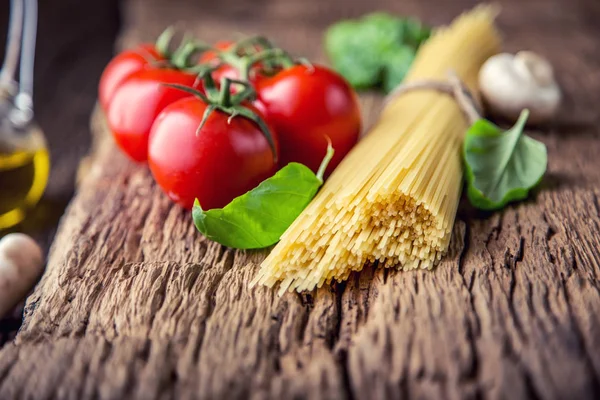Spaghetti.spaghetti tomaten basilikum olivenöl parmesankäse und pilze auf sehr altem eichenbrett. mediterrane Küche und Zutaten — Stockfoto
