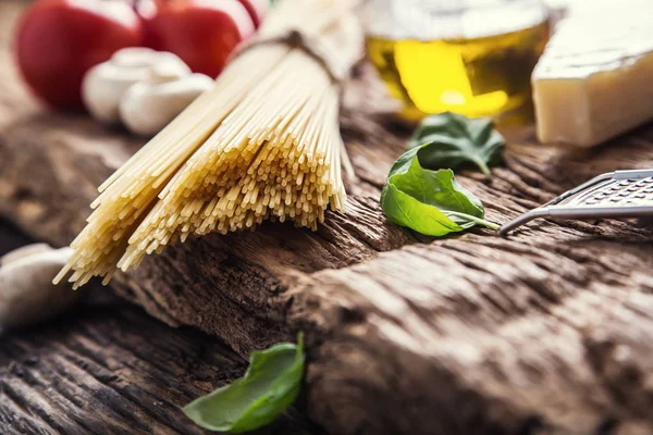 Spaghetti.Spaghetti tomaten basilicum olijfolie Parmezaanse kaas en champignons op zeer oude eiken bord. Mediterrane gerechten en ingrediënten — Stockfoto