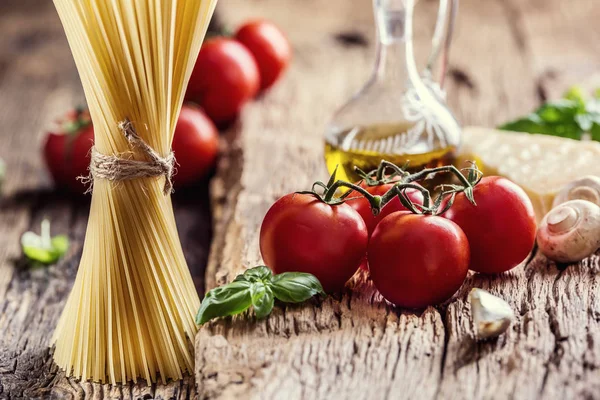 Spaghetti.Spaghetti domates fesleğen zeytinyağı parmesan peyniri ve mantarlar çok eski meşe tahtası üzerinde. Mediterrannean mutfağı ve malzemeler — Stok fotoğraf