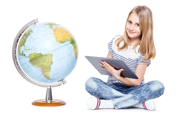 Pequena menina bonito com tablet e globo. Estudante usando tecnologia moderna no ensino de geografia — Fotografia de Stock