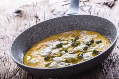 Yumurta kuşkonmaz ve peynir eski meşe masada seramik tavada omlet