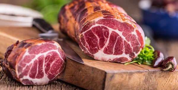 Carne di maiale. Costoletta di maiale affumicata. Carne affumicata tradizionale su tavola di legno di quercia in altre posizioni — Foto Stock