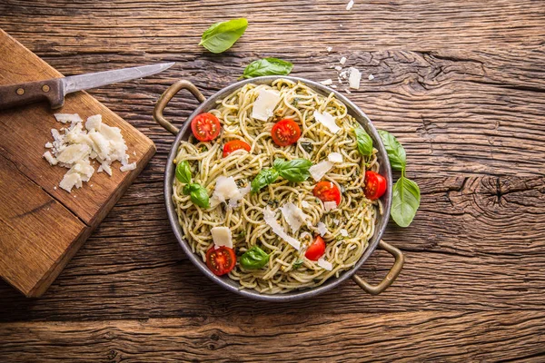 Espaguetis de pasta italiana con pesto de albahaca tomates cherry y aceite de oliva — Foto de Stock