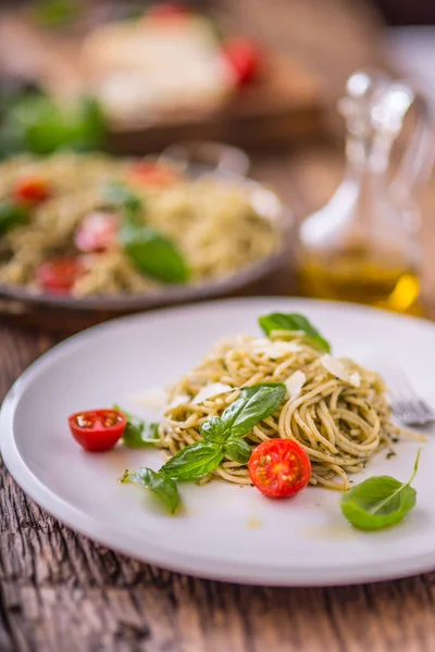 Espaguetis de pasta italiana con pesto de albahaca tomates cherry y aceite de oliva — Foto de Stock